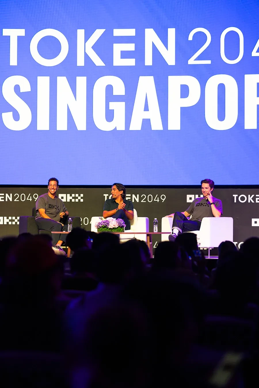 OKX Chief Marketing Officer Haider Rafique speaks with Danny Ricciardo and Scotty James, sporting stars and OKX Ambassadors, on the OKX Mainstage at Token2049